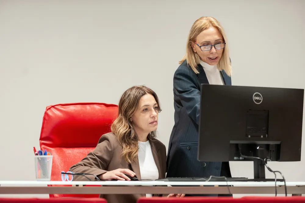 Lucia Di Paolo con una collaboratrice davanti al computer in studio